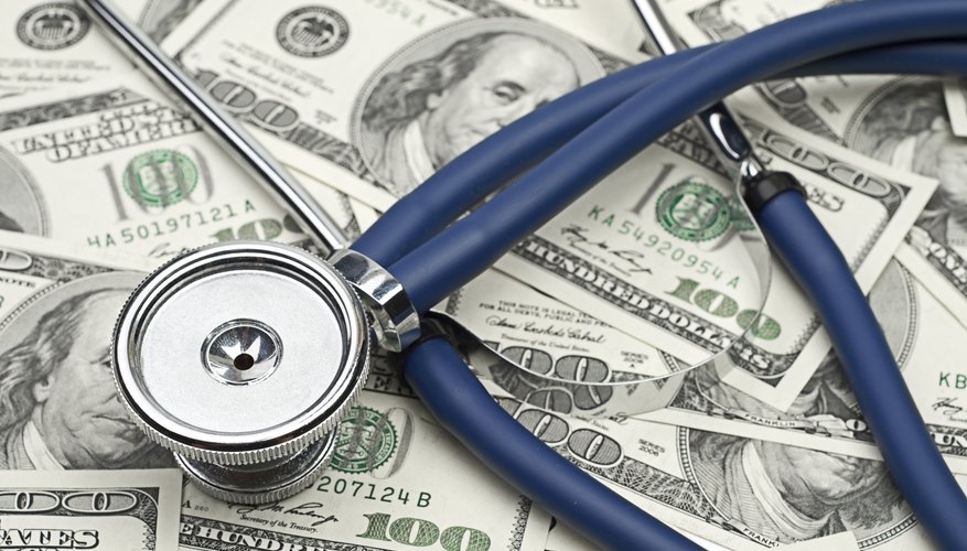 An overhead view of a stethoscope on bank notes.