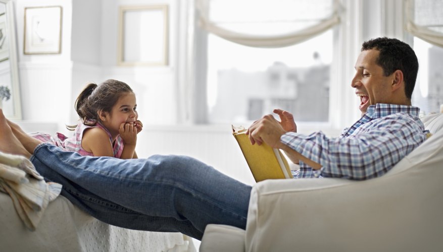 father reading book to his daughter father reading book to his daughter