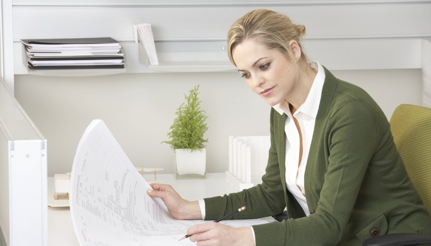 Young businesswoman looking at paperwork at desk