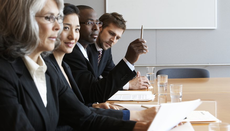 Executives in conference room reading documents, side view