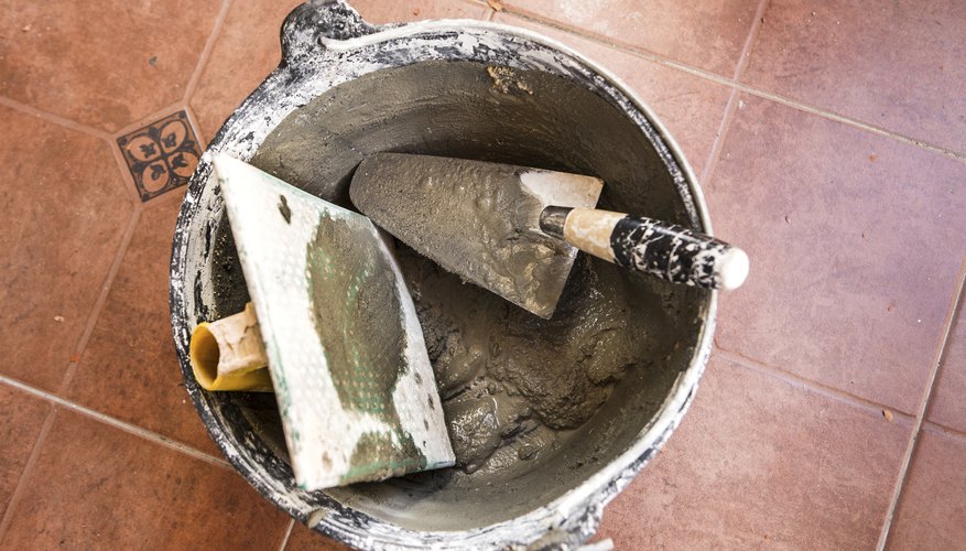 Photo Credit: Tingitania/iStock/Getty Images Close-up of a spatula and other tools in a bucket of cement