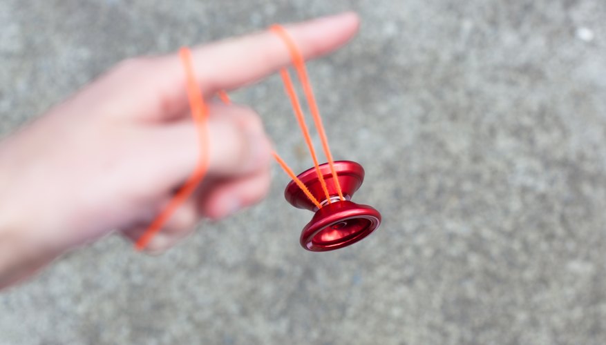 Photo Credit: Alex Wise/iStock/Getty Images Wind the string around the yo-yo, and place the string loop around your middle finger.