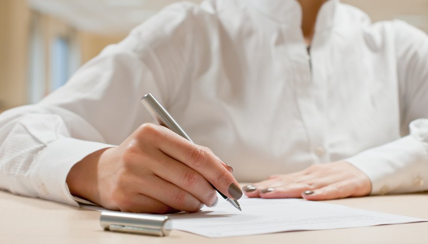 A woman is signing a contract.