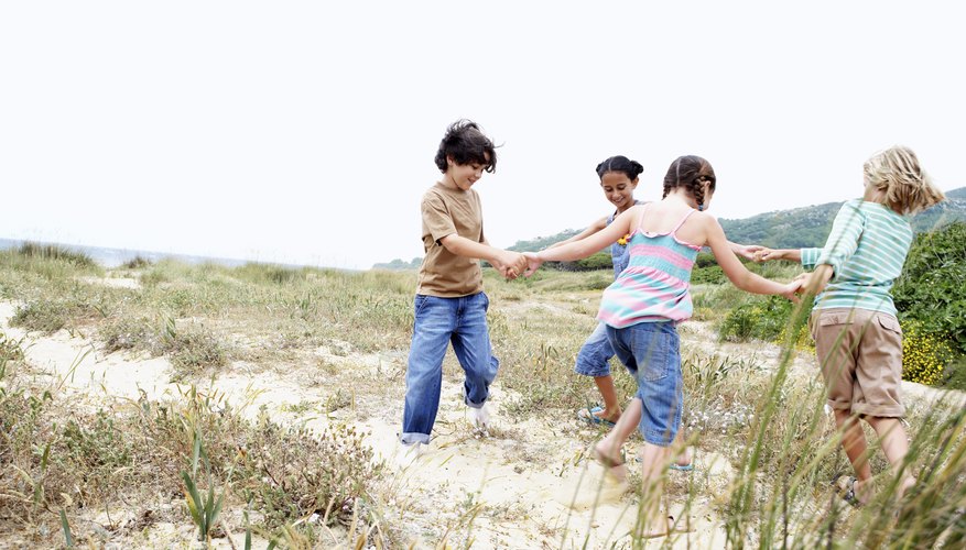 Children holding hands while playing in field. Children holding hands while playing in field.