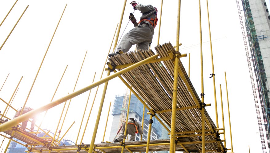 Photo Credit: hxdbzxy/iStock/Getty Images Workers on scaffolding wearing safety harnesses