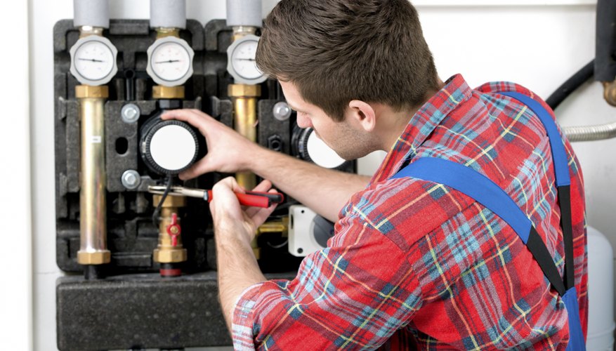 Technician servicing heating boiler