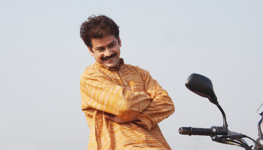 Man sitting on motor cycle, low angle view