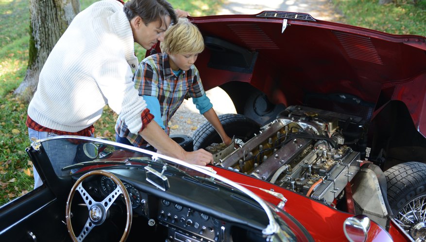 Photo Credit: altrendo images/Stockbyte/Getty Images Father and son looking at classic car engine
