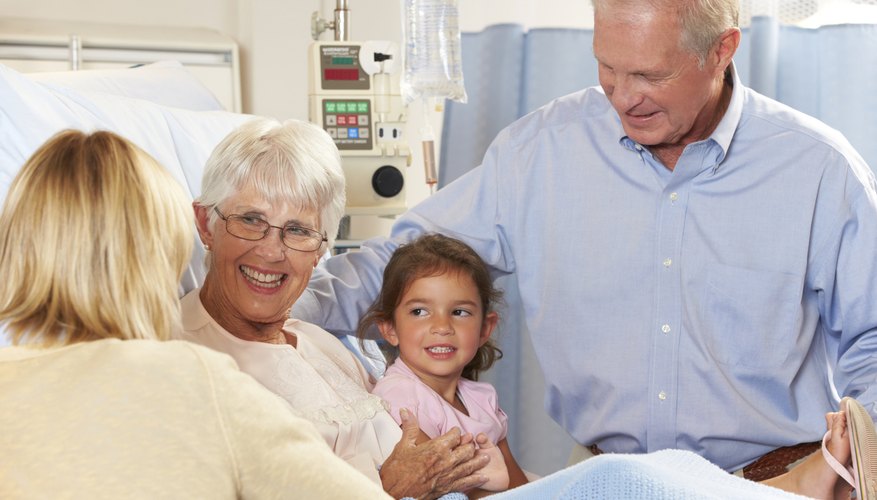Family Visiting Senior Female Patient In Hospital Bed