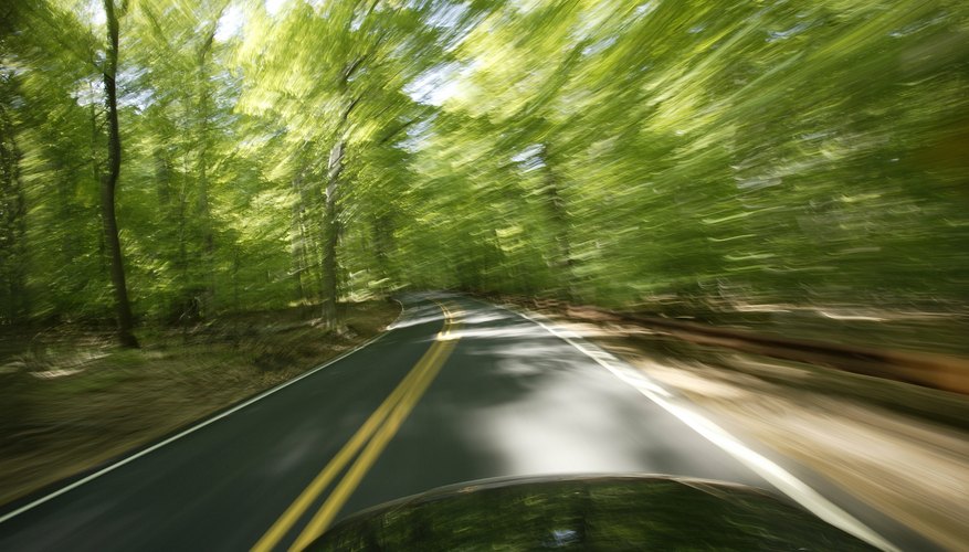 Blur of trees from car driving on road