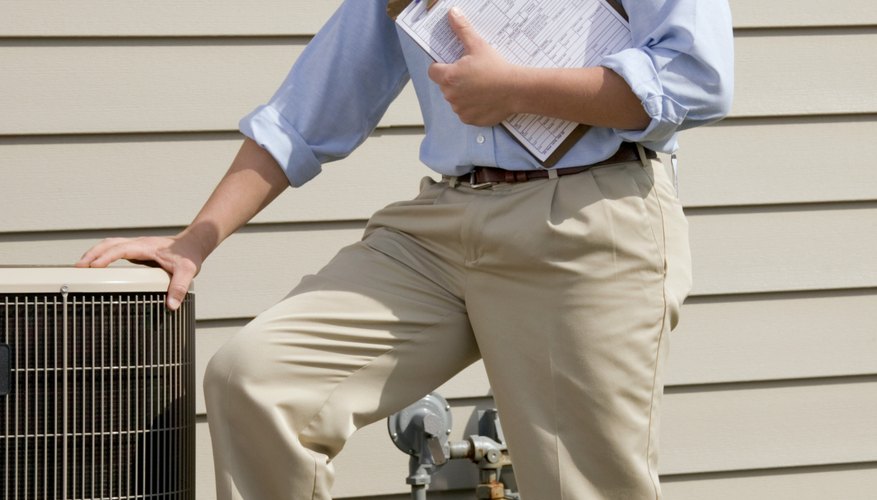 Man with clipboard standing near air conditioning unit