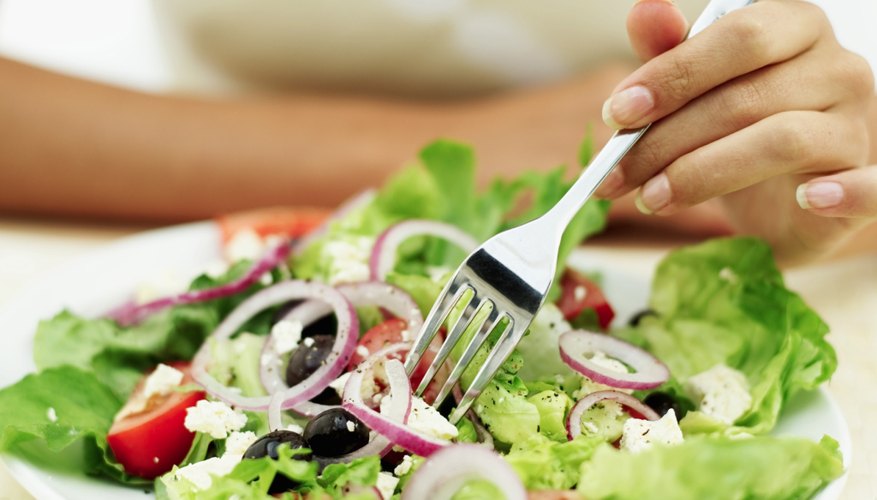 A woman eats a small salad. A woman eats a small salad.