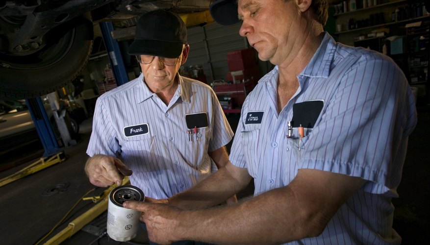 Mechanics looking at oil filter