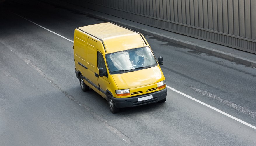Yellow cargo van on road.