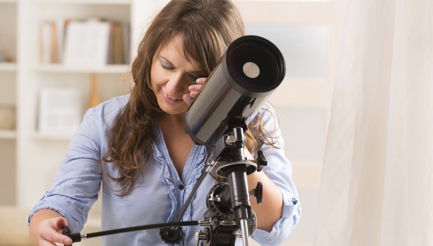 Photo Credit: humonia/iStock/Getty Images Young woman using a telescope.