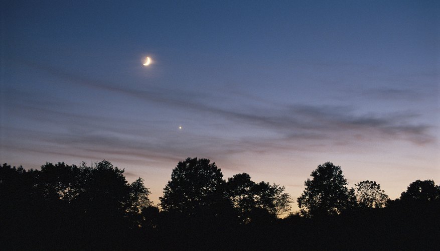 The planet Venus appears just below the moon in the evening sky.