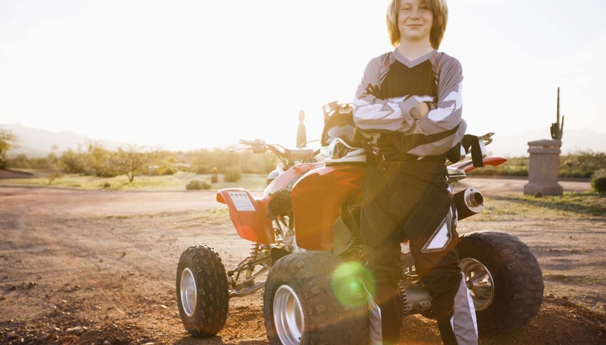 Boy posing by ATV, Arizona