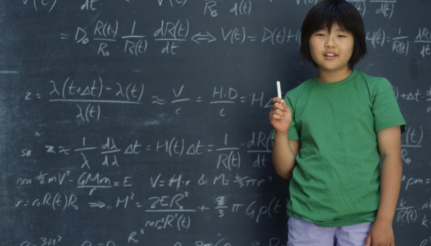 Student Holding Chalk In Front Of Board With Math Problems