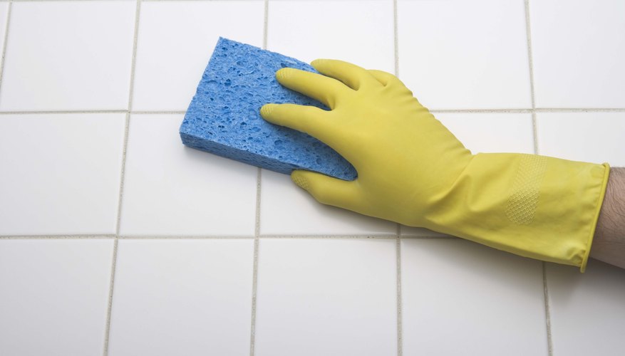 Photo Credit: Jupiterimages/Stockbyte/Getty Images A gloved hand is cleaning the kitchen floor.