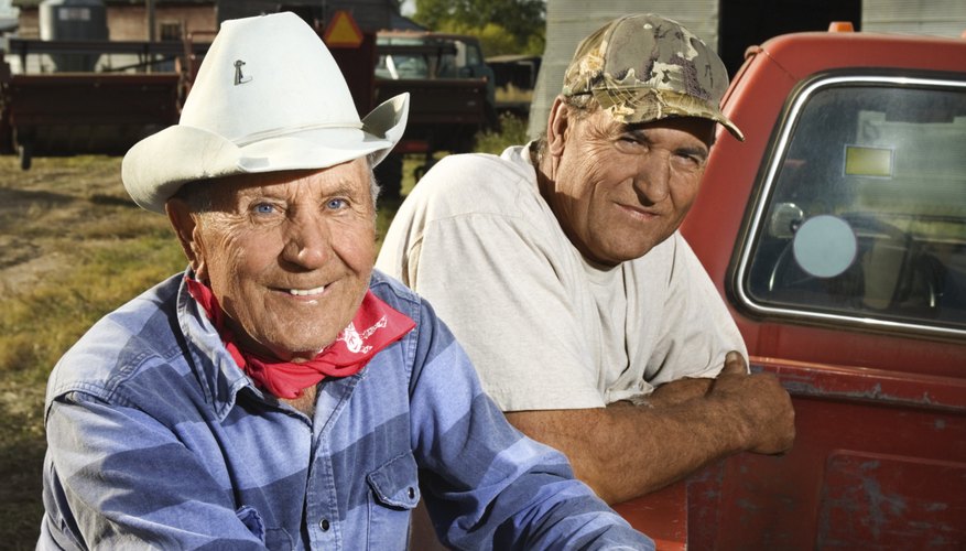 Men leaning on pickup truck smiling