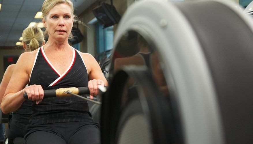 A woman exercises on a rowing machine. A woman exercises on a rowing machine.