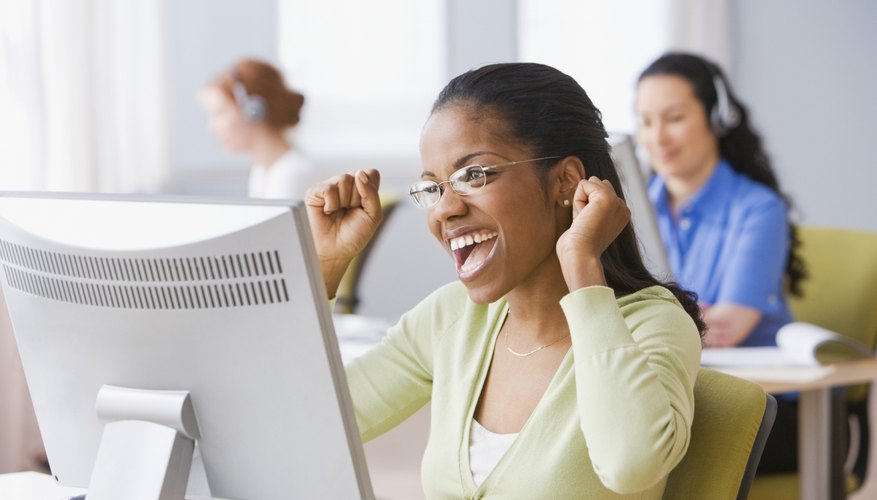 African businesswoman cheering at desk