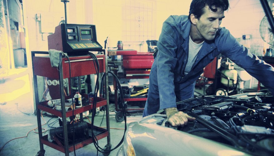 Auto mechanic working over the engine bay of a car