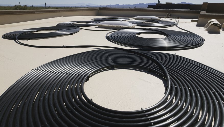 Photo Credit: Jupiterimages/Stockbyte/Getty Images solar water pipes on a rooftop