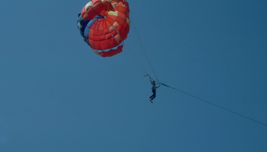 Photo Credit: Jupiterimages/Photos.com/Getty Images Air resistance works against gravity to help parachuters descend safely to the ground.