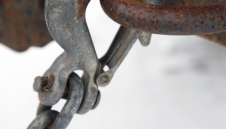 Close-up of hook and chain on rusty bumper of vehicle