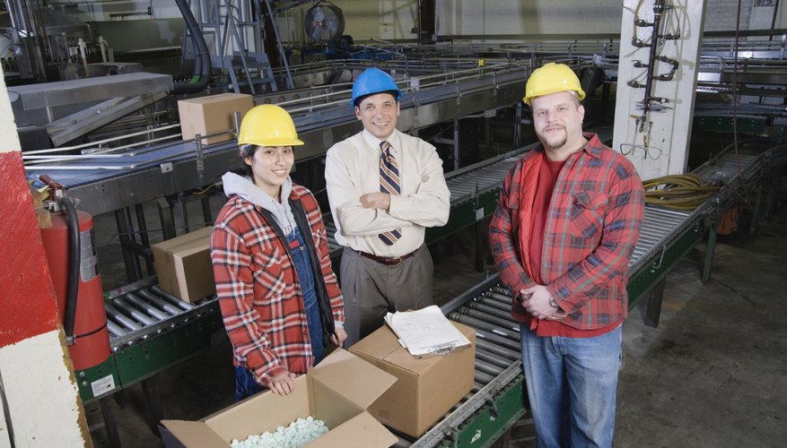Three people in warehouse looking at camera