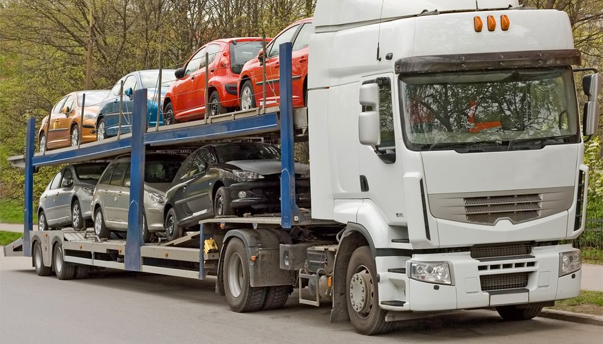 Truck transporting new cars.