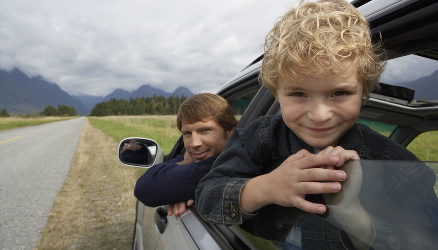 A father and son looking out car windows during a day trip. A father and son looking out car windows during a day trip.