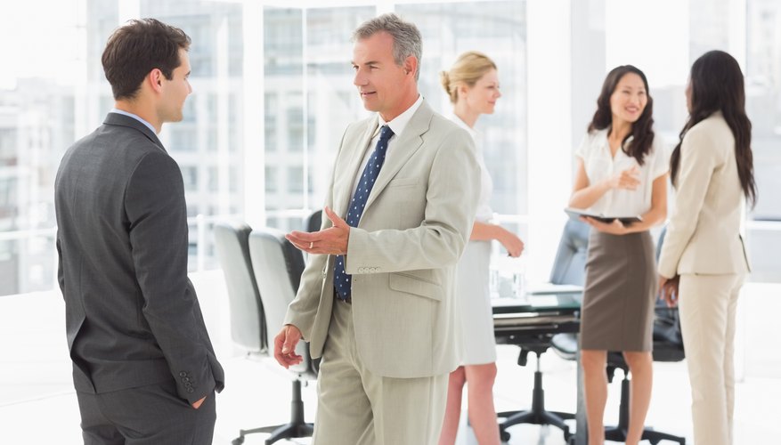 Business people speaking together in conference room