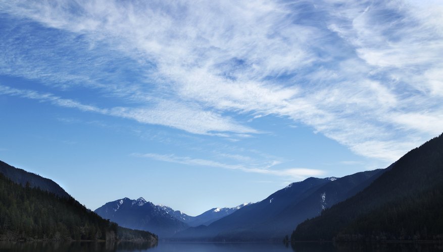 Photo Credit: Ryan McVay/Photodisc/Getty Images Clouds in the blue sky hovering over a lake in the mountains.