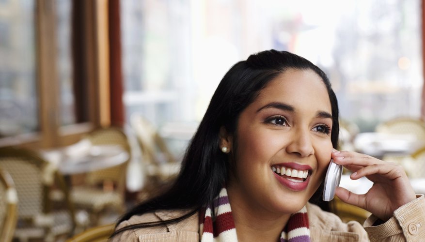 Young woman using mobile phone, smiling