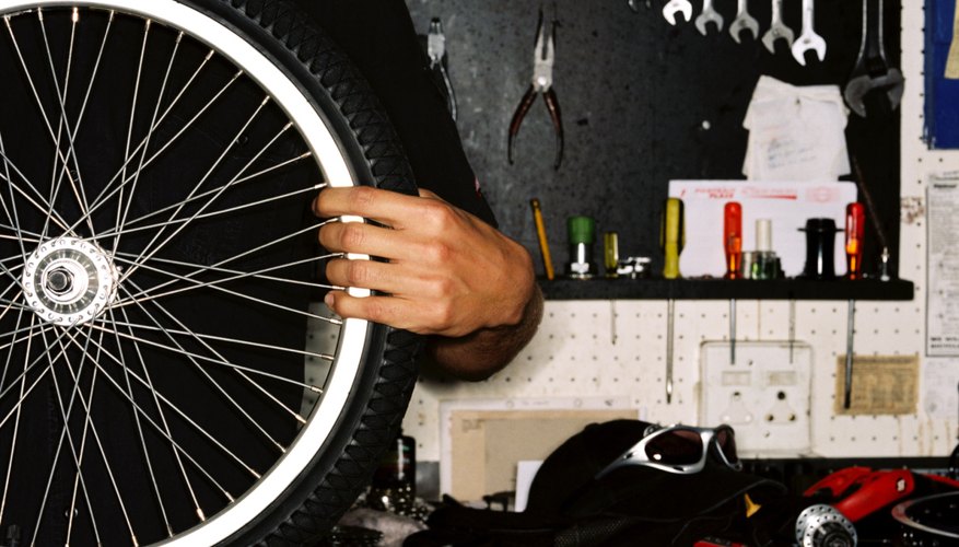 Mid section of a person holding a bicycle wheel rim