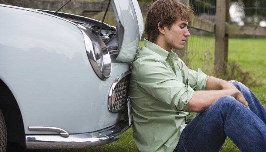 Man sitting by car with car trouble
