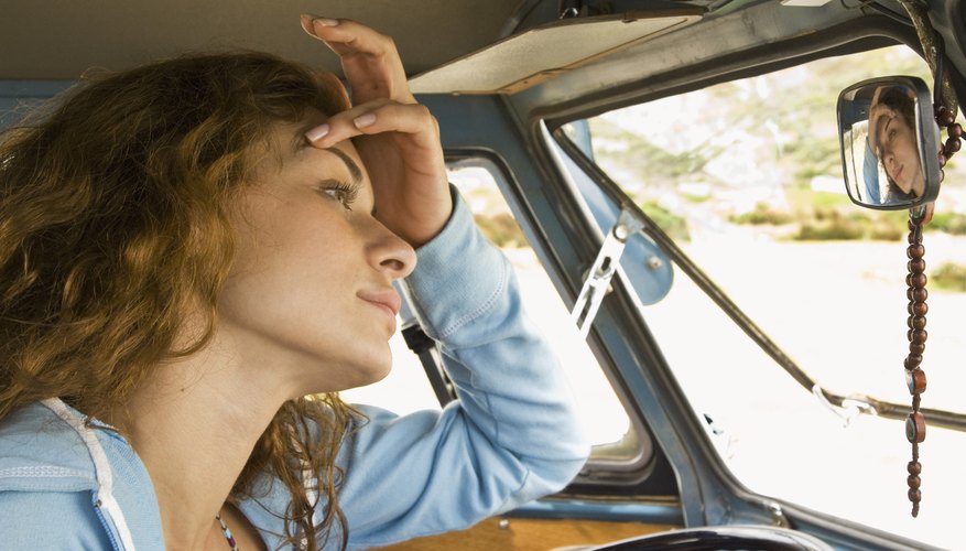 Woman looking in mirror in van