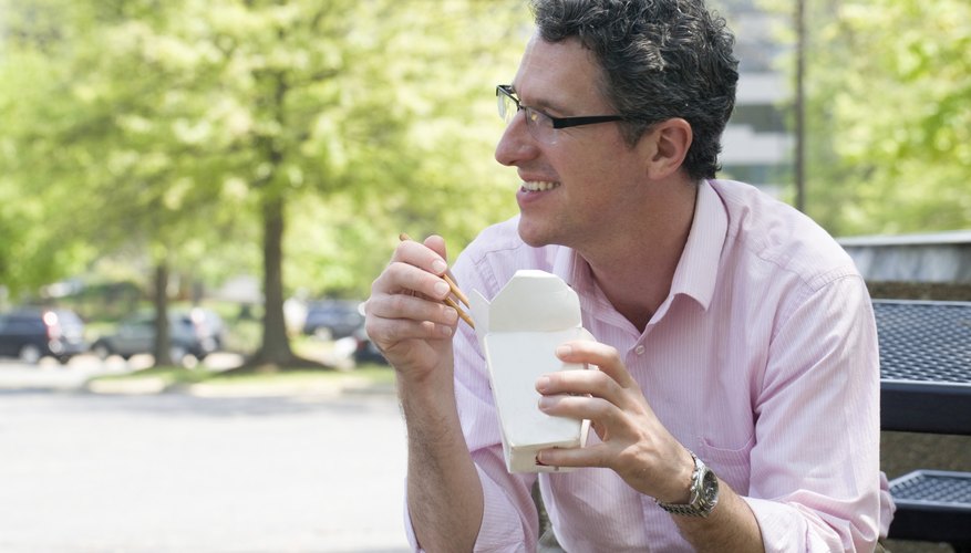 Mature businessman enjoys Chinese carry out for his lunch