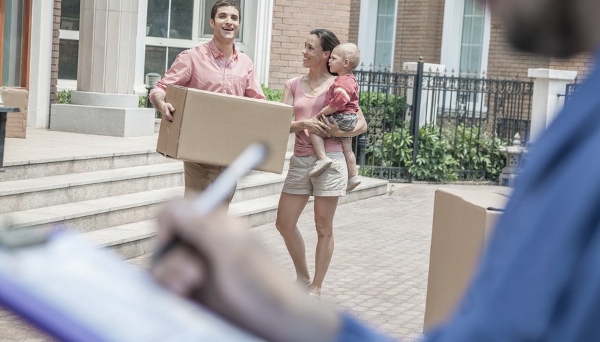 Mover holding clipboard and invoice, family in the background