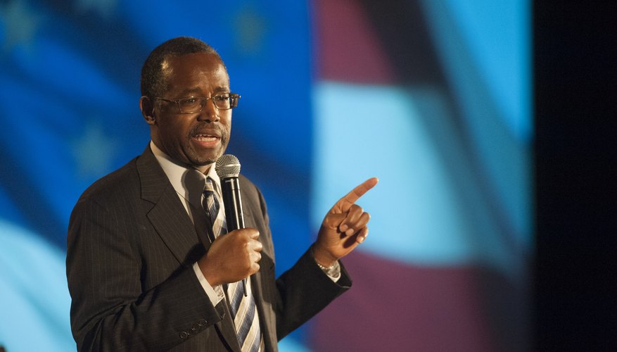 Photo Credit: Laura Segall/Getty Images News/Getty Images A professsional speaker talking into the microphone on stage.
