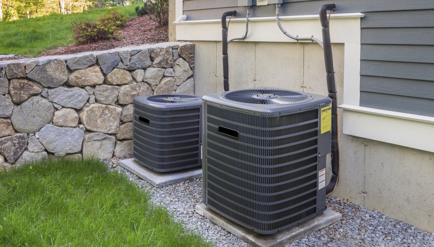 Central air conditioning units in place in the backyard of a home.