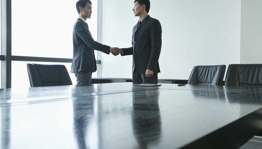 Businessmen shaking hands in meeting room