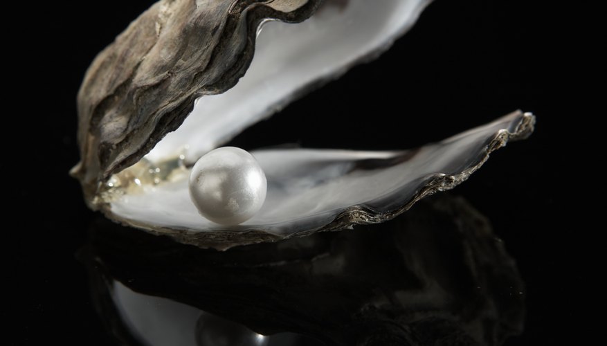 Cultured pearl on black background defines iridescent finish. Cultured pearl on black background defines iridescent finish.