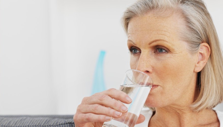 Older woman drinking glass of water. Older woman drinking glass of water.