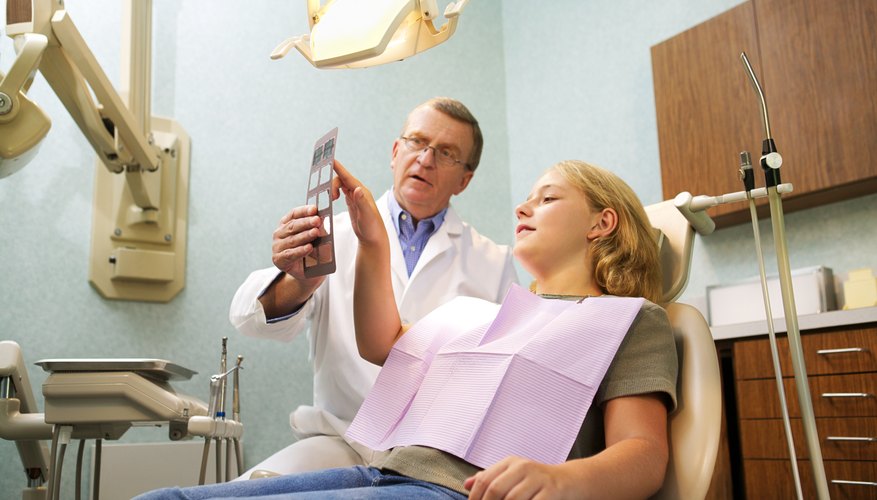 Dentist showing patient X-rays of teeth Dentist showing patient X-rays of teeth