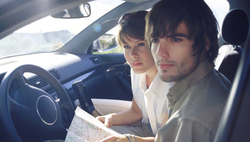 Couple in car looking at map for directions