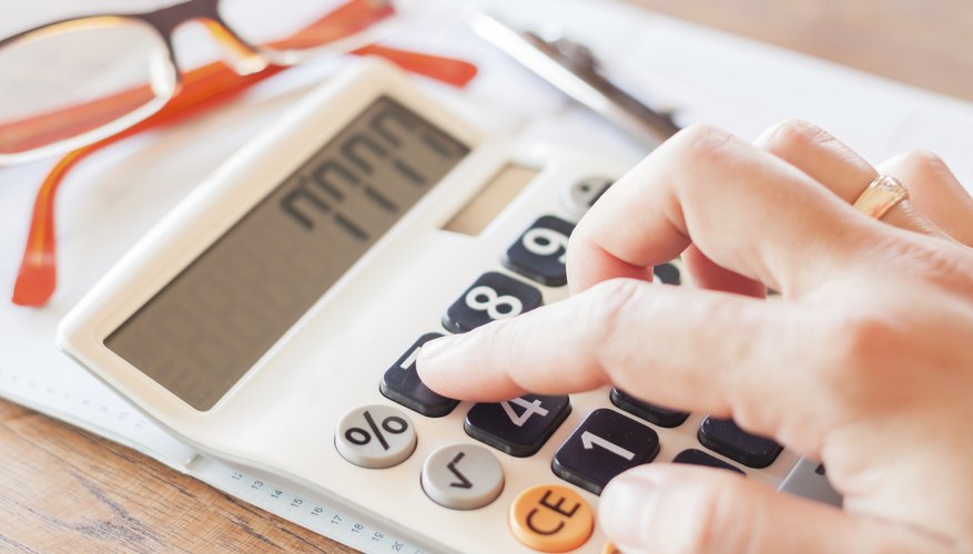 Businesswoman working in coffee shop with calculator