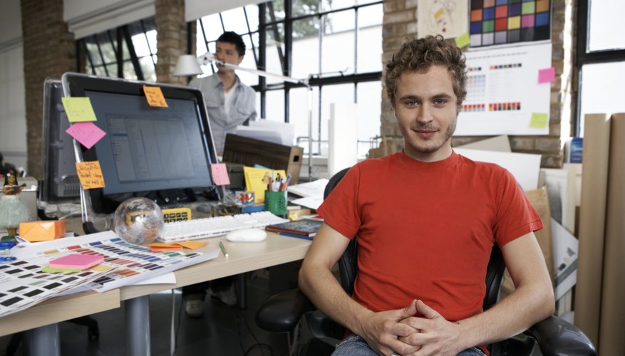 Photo Credit: Ciaran Griffin/Photodisc/Getty Images A designer sits at a desk in a modern office.